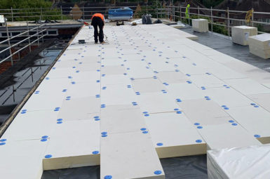 worker replacing commercial flat roofing in london