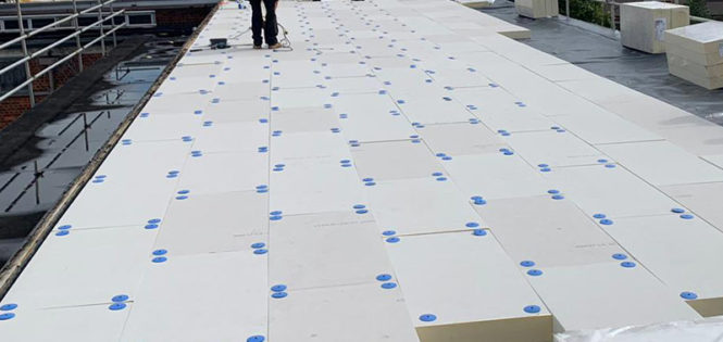 worker replacing commercial flat roofing in london